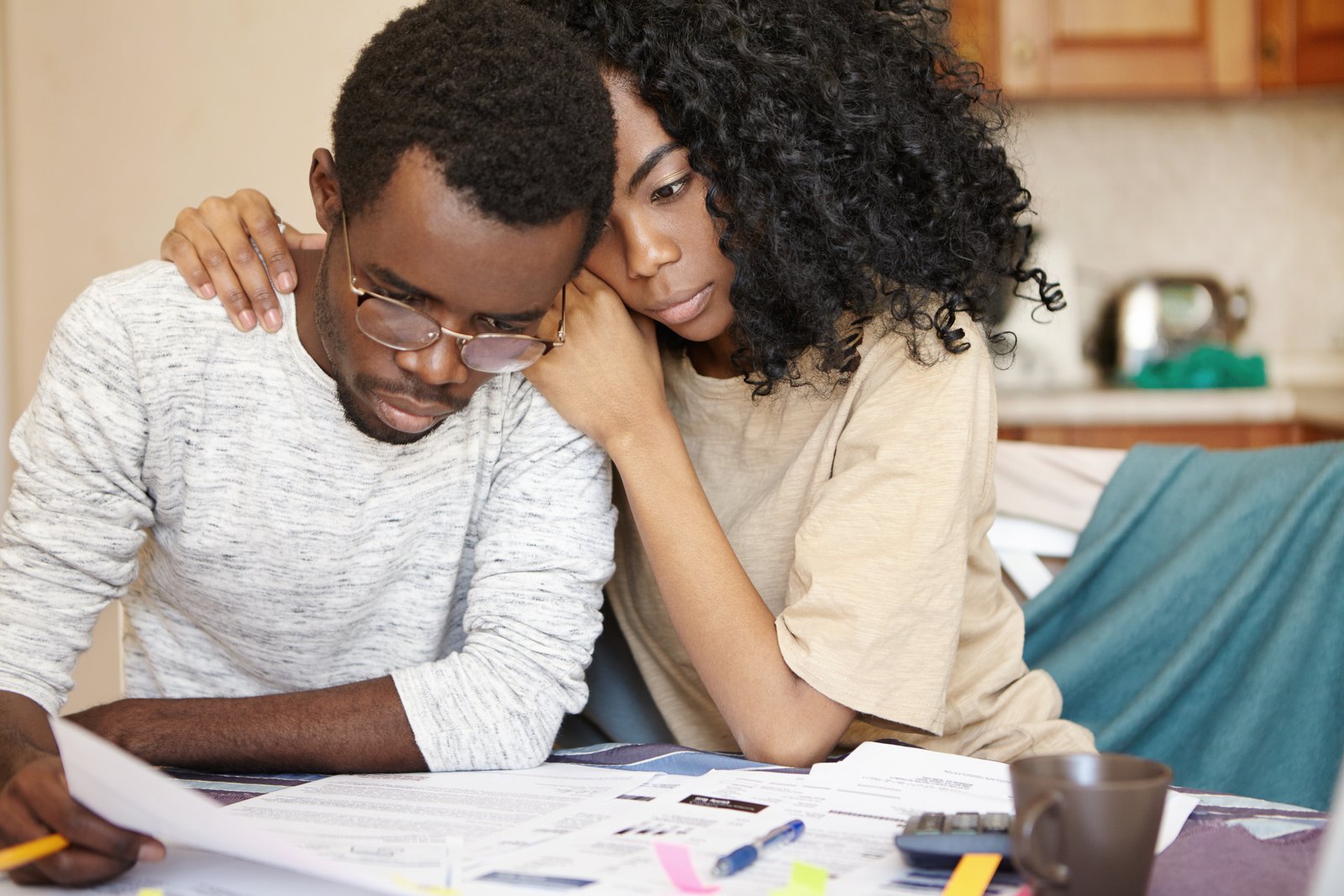 frustrated-african-man-wearing-spectacles-doing-paperwork-kitchen-table.jpg